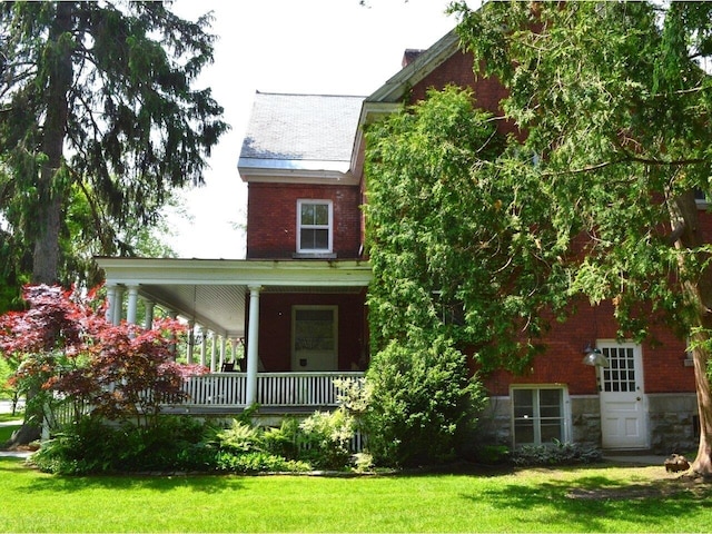 406 Dalton Dr Unit D, Colchester, VT 05446 - back of house with a porch, a lawn, stone siding, and brick siding