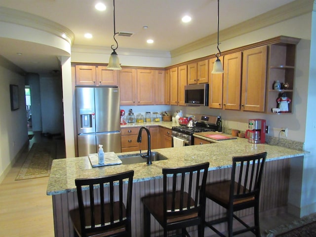 616 Scenic Rd Unit 102, Laconia, NH 03246 - kitchen featuring stainless steel appliances, a sink, crown molding, brown cabinetry, and light stone countertops