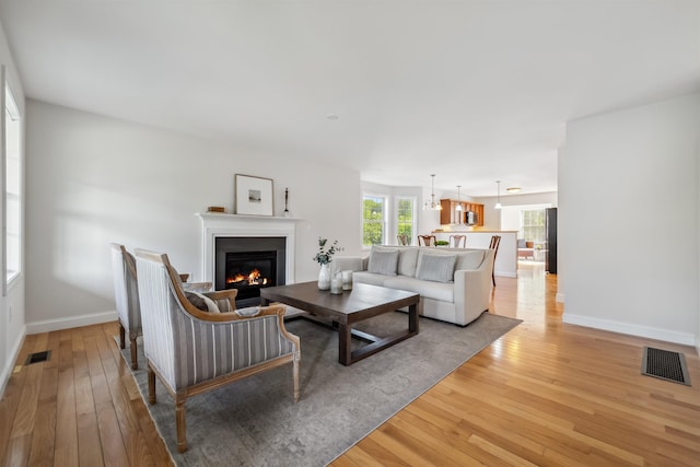 67 Leddy Dr, Epping, NH 03042 - living area featuring light wood-style floors, a glass covered fireplace, and baseboards