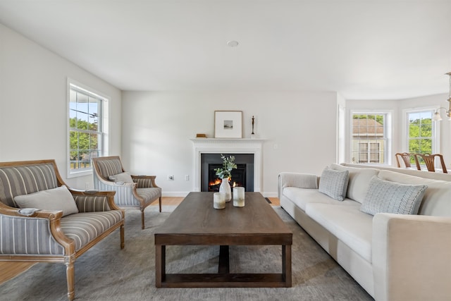 67 Leddy Dr, Epping, NH 03042 - living area featuring healthy amount of natural light, wood finished floors, and a warm lit fireplace