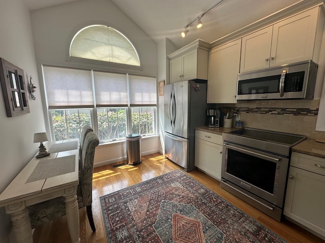 60 Skyline Dr, Keene, NH 03431 - kitchen with stainless steel appliances, backsplash, light wood-style floors, vaulted ceiling, and rail lighting
