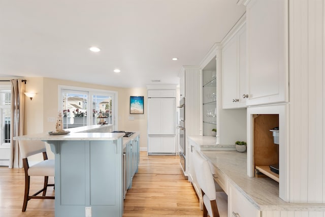 30 Ancient Hwy, Hampton, NH 03842 - kitchen featuring white cabinetry, light wood finished floors, a kitchen breakfast bar, paneled built in fridge, and recessed lighting