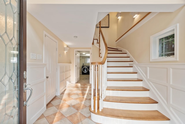 30 Ancient Hwy, Hampton, NH 03842 - foyer featuring washer / clothes dryer, a decorative wall, stairway, a wainscoted wall, and light tile patterned floors
