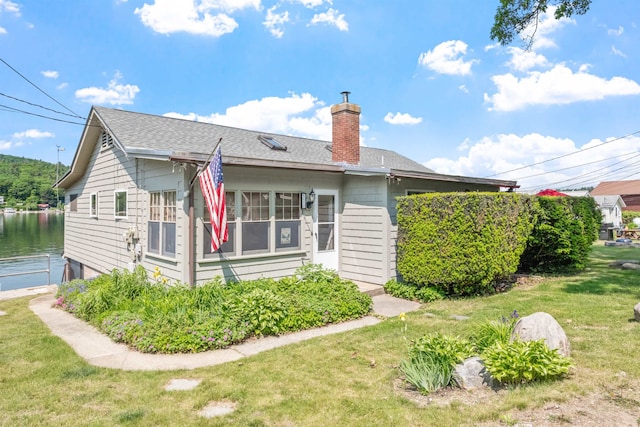 57 Lakeside Rd, Bristol, NH 03222 - back of property with a chimney, a lawn, and roof with shingles