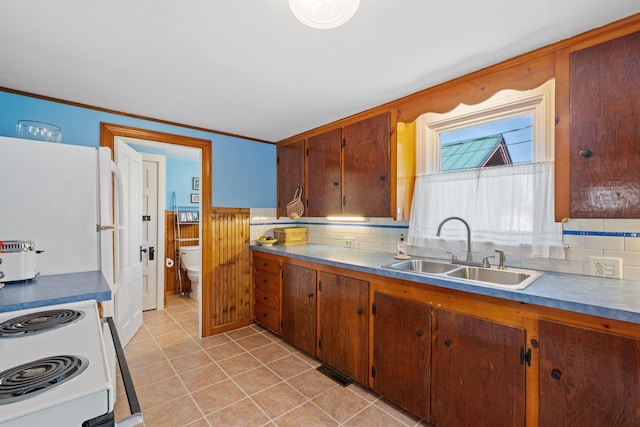 57 Lakeside Rd, Bristol, NH 03222 - kitchen featuring a sink, white appliances, light tile patterned flooring, crown molding, and brown cabinetry
