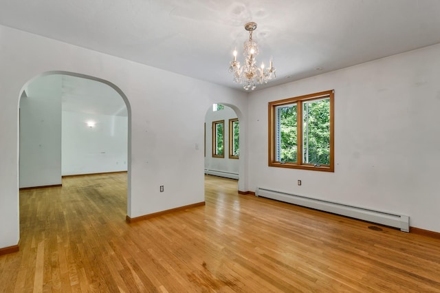 161 Frank C Gilman Hwy, Alton, NH 03809 - unfurnished room with baseboard heating, arched walkways, light wood-style flooring, and a chandelier