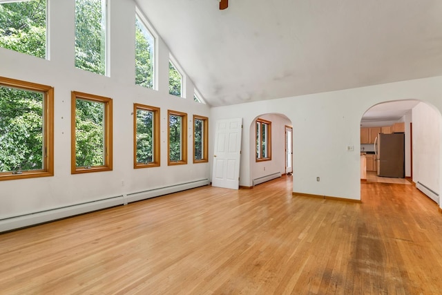 161 Frank C Gilman Hwy, Alton, NH 03809 - unfurnished living room featuring high vaulted ceiling, baseboard heating, light wood-style floors, and arched walkways