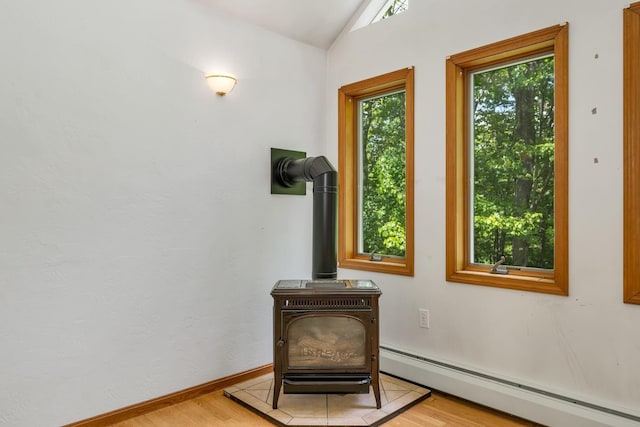 161 Frank C Gilman Hwy, Alton, NH 03809 - detailed view of a wood stove, a baseboard heating unit, wood finished floors, and baseboards