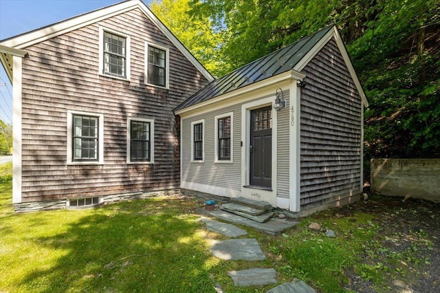 4780 Mountain Rd, Stowe, VT 05672 - view of front of house featuring entry steps, a standing seam roof, metal roof, a front yard, and an outdoor structure