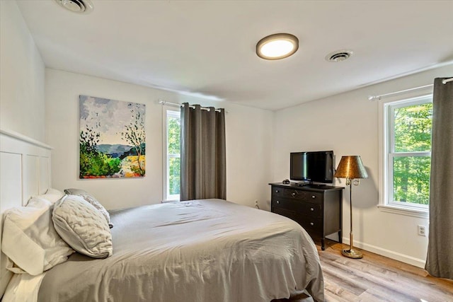 165 Golf Course Rd, Warren, VT 05674 - bedroom with multiple windows, light wood-type flooring, and baseboards