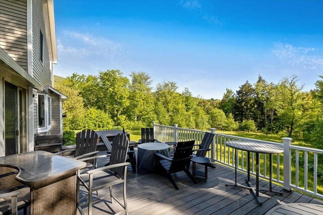 165 Golf Course Rd, Warren, VT 05674 - wooden deck featuring outdoor dining area and a view of trees