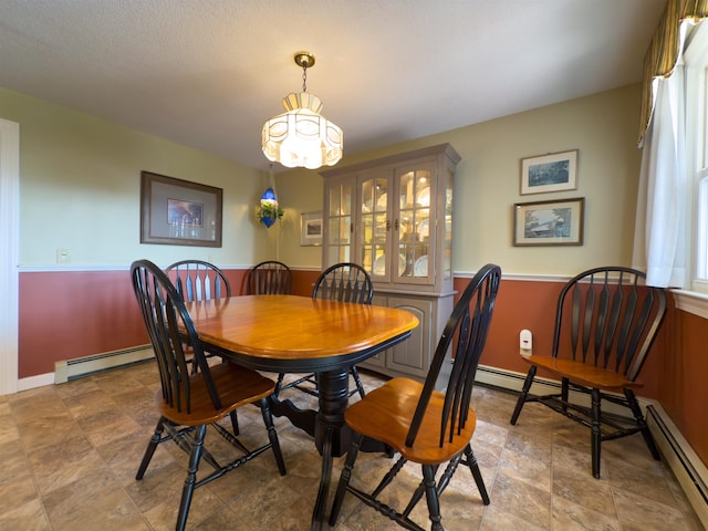 402 E Rd, Cornish, NH 03745 - dining space with a chandelier, a baseboard heating unit, a wainscoted wall, and stone finish flooring