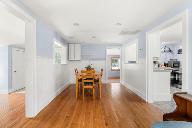 20 Circuit Dr, Kingston, NH 03848 - dining space featuring light wood-type flooring, a wainscoted wall, and baseboards