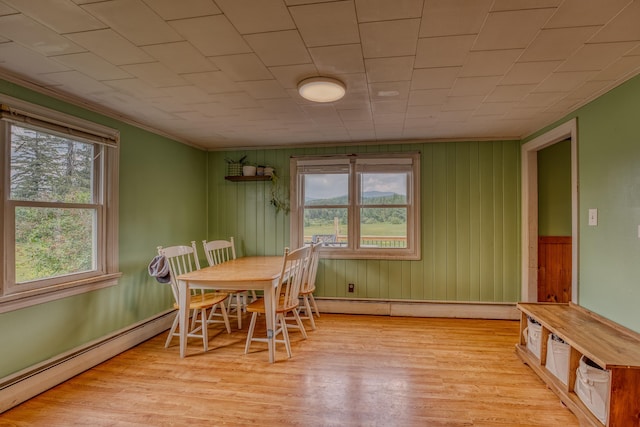 336 N Rd, Lancaster, NH 03584 - dining space with baseboard heating, plenty of natural light, light wood-style floors, wood walls, and crown molding