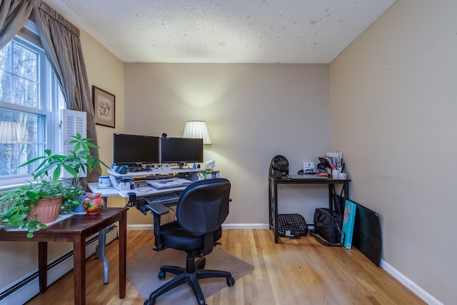 50 Kienia Rd, Hudson, NH 03051 - office area featuring wood finished floors, baseboards, a baseboard heating unit, and a textured ceiling
