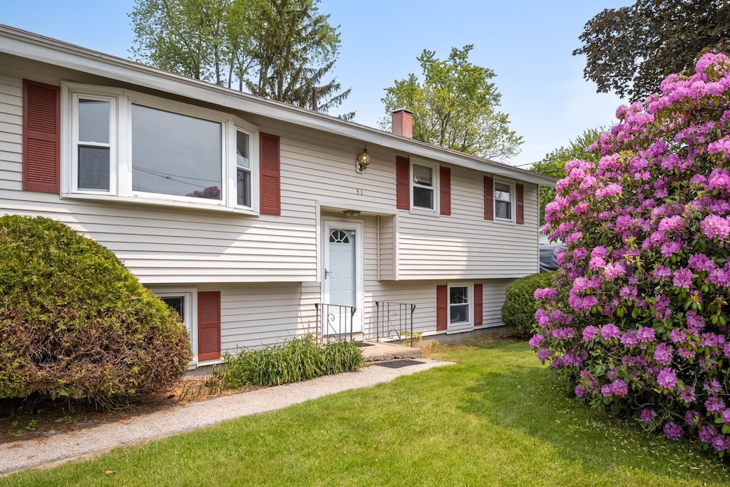 31 Pelham St, Nashua, NH 03060 - bi-level home featuring a front yard and a chimney