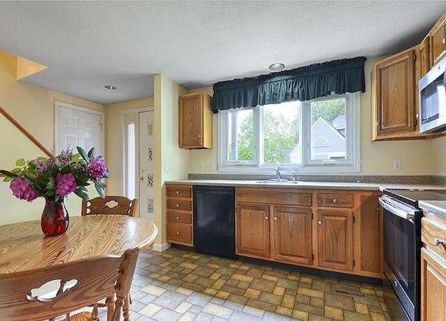 1 Wesley Ln, Keene, NH 03431 - kitchen with stainless steel appliances, a sink, brown cabinets, and a textured ceiling