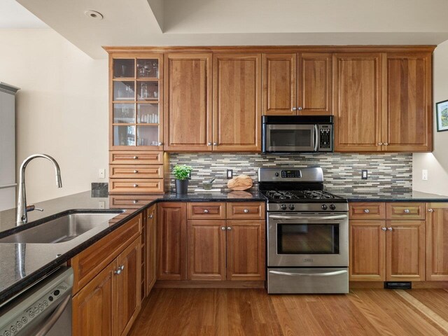 200 Lake St Unit 16, Burlington, VT 05401 - kitchen with appliances with stainless steel finishes, a sink, wood finished floors, and brown cabinetry