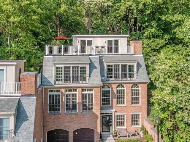 200 Lake St Unit 16, Burlington, VT 05401 - back of property featuring a balcony, brick siding, an attached garage, and a chimney