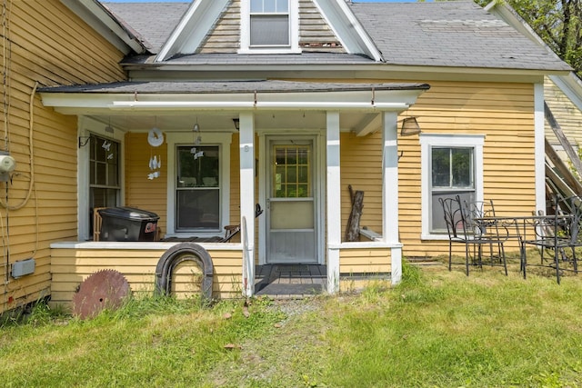 9 Laurel St, Whitefield, NH 03598 - view of exterior entry with a porch, a shingled roof, and a lawn