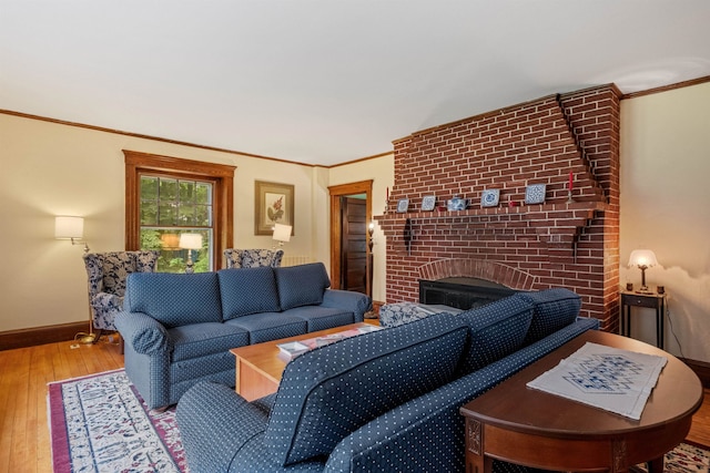living area featuring a fireplace, hardwood / wood-style floors, baseboards, and ornamental molding