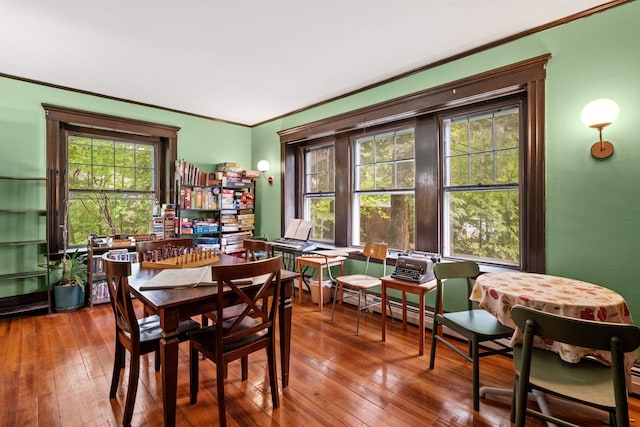 dining space featuring hardwood / wood-style flooring and ornamental molding