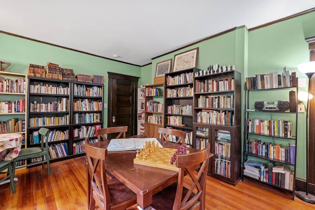 office featuring bookshelves, wood finished floors, and crown molding