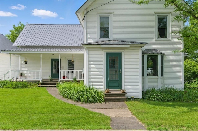 203 N Pleasant St, Troy, VT 05859 - view of front of home featuring a front lawn, covered porch, and metal roof