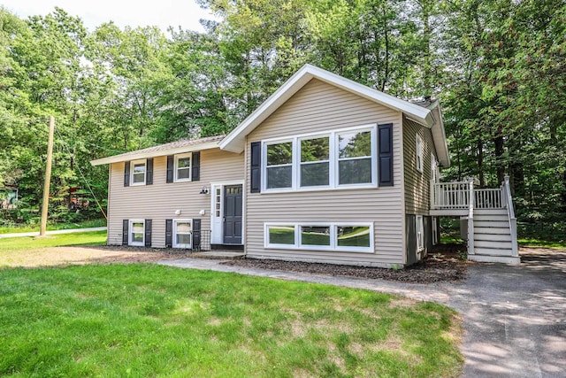 21 Ridgefield Dr, Milford, NH 03055 - split foyer home featuring stairs, a front lawn, a wooden deck, and view of scattered trees