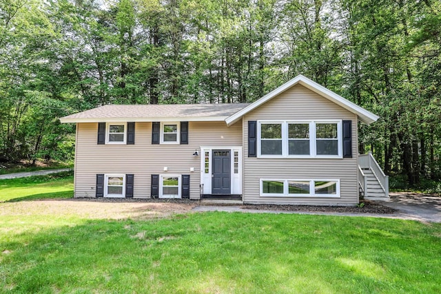 21 Ridgefield Dr, Milford, NH 03055 - raised ranch featuring a front yard, stairs, and view of wooded area