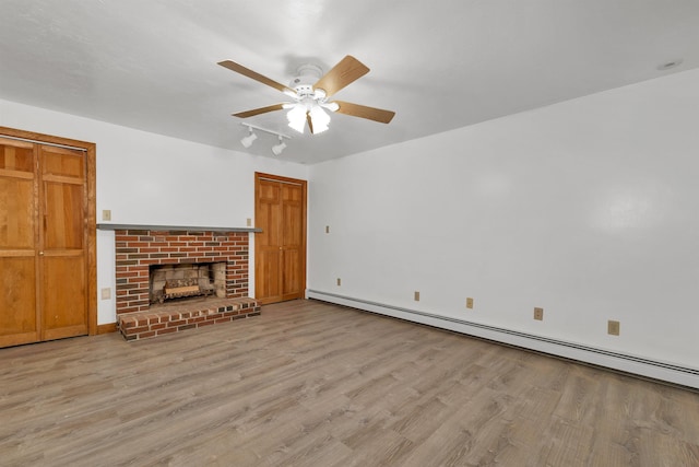 5 Lucerne Dr, Madison, NH 03849 - unfurnished living room with baseboard heating, a ceiling fan, wood finished floors, and a fireplace