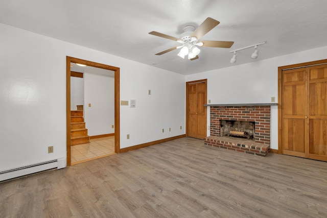 5 Lucerne Dr, Madison, NH 03849 - unfurnished living room with wood finished floors, ceiling fan, a baseboard radiator, track lighting, and a brick fireplace