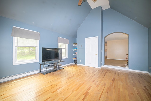 20 Locke Hill Ln, Barrington, NH 03825 - unfurnished living room featuring arched walkways, wood finished floors, ceiling fan, high vaulted ceiling, and baseboards