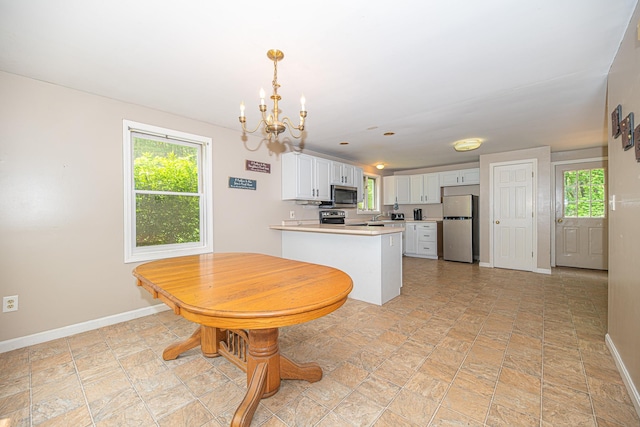 20 Locke Hill Ln, Barrington, NH 03825 - kitchen with stainless steel appliances, a chandelier, baseboards, and white cabinetry