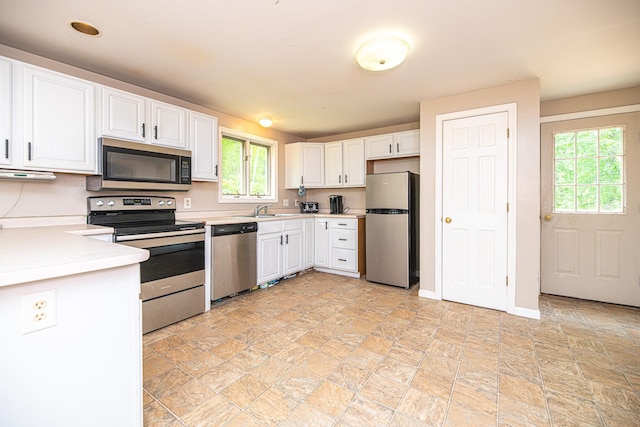 20 Locke Hill Ln, Barrington, NH 03825 - kitchen with stainless steel appliances, a sink, white cabinets, light countertops, and light stone finish flooring