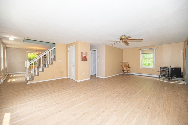 20 Locke Hill Ln, Barrington, NH 03825 - unfurnished living room featuring a wood stove, stairs, light wood-style floors, and baseboards