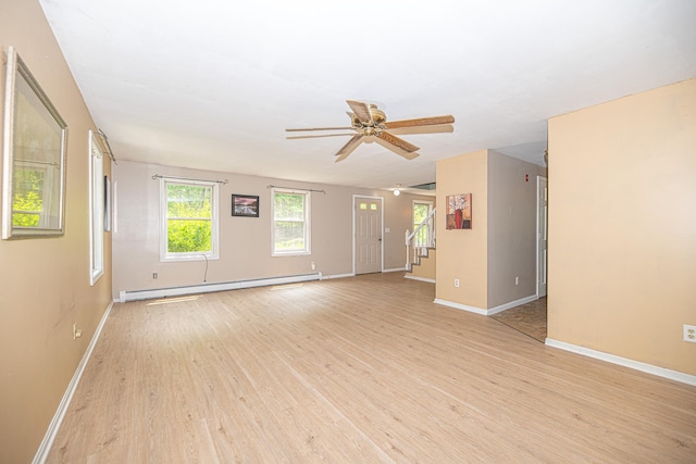 20 Locke Hill Ln, Barrington, NH 03825 - spare room featuring a baseboard heating unit, light wood finished floors, ceiling fan, baseboards, and stairway