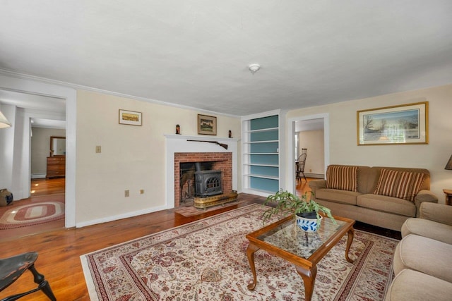 196 Deering Center Rd, Weare, NH 03281 - living room with wood finished floors, a wood stove, built in features, baseboards, and a baseboard heating unit
