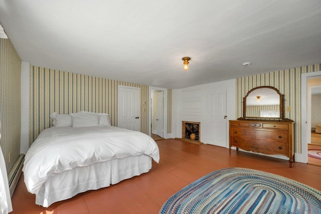196 Deering Center Rd, Weare, NH 03281 - bedroom featuring wallpapered walls, wood finished floors, a baseboard radiator, and a fireplace