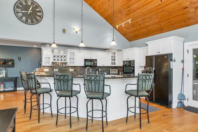 7 Acorn Dr, Alton, NH 03810 - kitchen with black appliances, high vaulted ceiling, white cabinetry, backsplash, and light wood-style floors