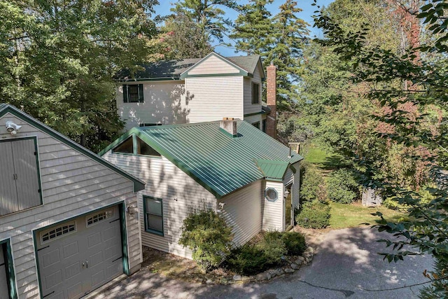 7 Acorn Dr, Alton, NH 03810 - view of side of home featuring a standing seam roof, metal roof, an attached garage, a chimney, and driveway