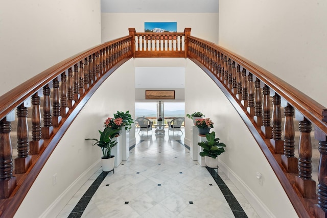 33 Winterberry Ln, Plymouth, NH 03264 - staircase featuring inlaid floor details, baseboards, a towering ceiling, and arched walkways