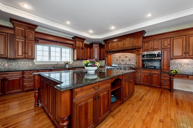 33 Winterberry Ln, Plymouth, NH 03264 - kitchen with stainless steel microwave, a sink, a center island with sink, light wood-style floors, and crown molding