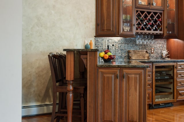 33 Winterberry Ln, Plymouth, NH 03264 - indoor wet bar featuring a baseboard radiator, decorative backsplash, beverage cooler, and wood finished floors
