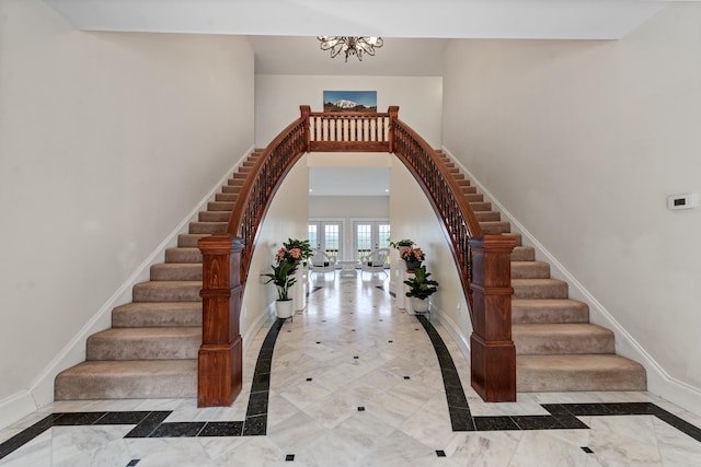 33 Winterberry Ln, Plymouth, NH 03264 - staircase featuring inlaid floor details, a chandelier, baseboards, and a high ceiling