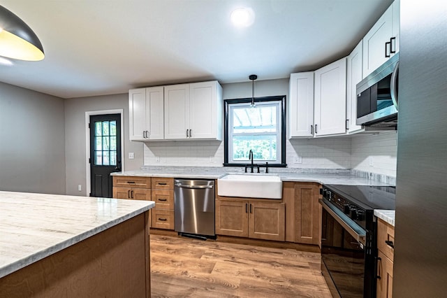 110 Currier Rd, Candia, NH 03034 - kitchen with appliances with stainless steel finishes, a sink, light wood-type flooring, backsplash, and white cabinets