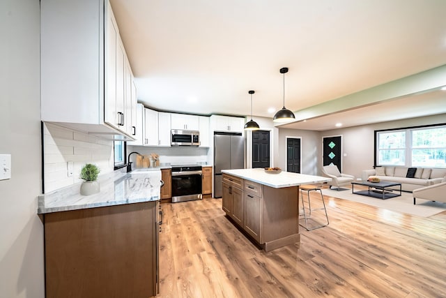 110 Currier Rd, Candia, NH 03034 - kitchen featuring stainless steel appliances, a breakfast bar, open floor plan, recessed lighting, and backsplash