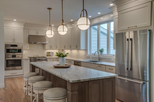 338 Pine Hill Rd, Hollis, NH 03049 - kitchen with appliances with stainless steel finishes, under cabinet range hood, a sink, decorative backsplash, and a center island