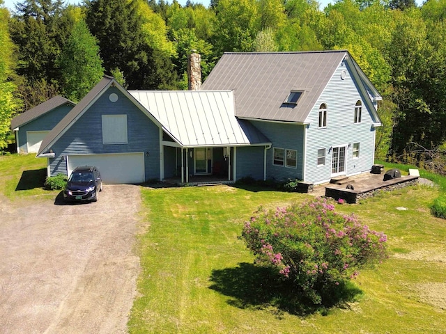 296 Atwood Rd, Duxbury, VT 05676 - view of front of house with dirt driveway, an attached garage, a front lawn, a chimney, and metal roof