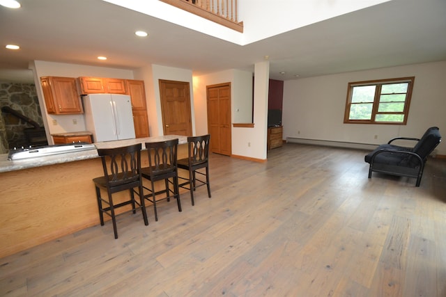 296 Atwood Rd, Duxbury, VT 05676 - kitchen featuring freestanding refrigerator, baseboard heating, light wood finished floors, a breakfast bar, and recessed lighting